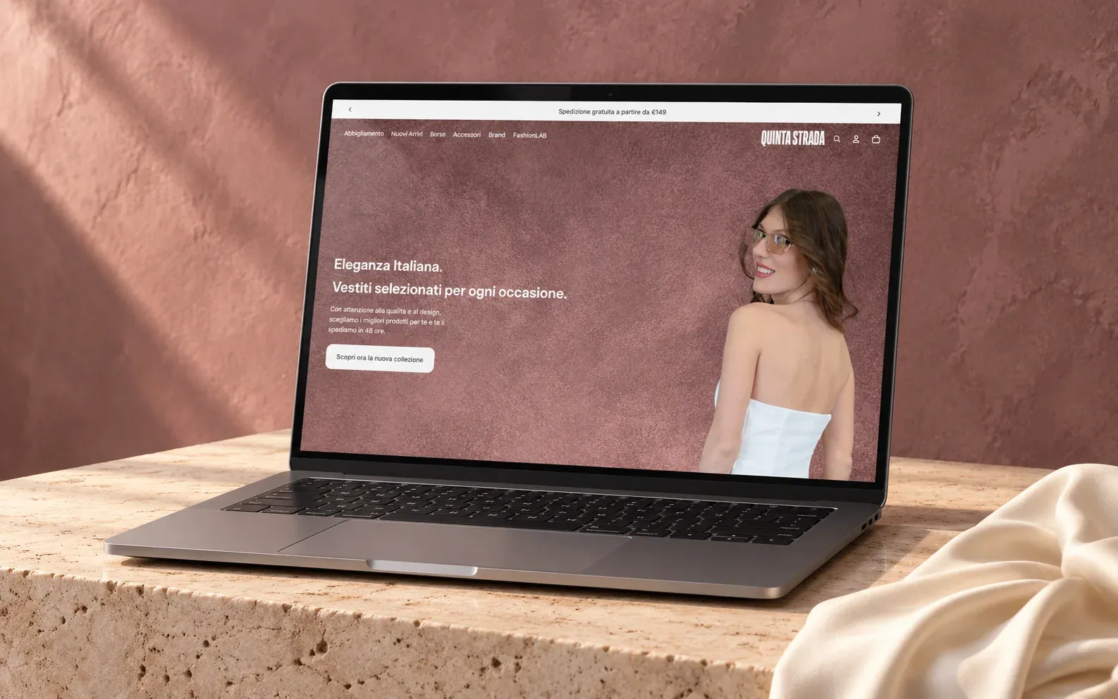 Homepage dell'e-commerce Shopify di Quinta Strada su un laptop appoggiato su travertino