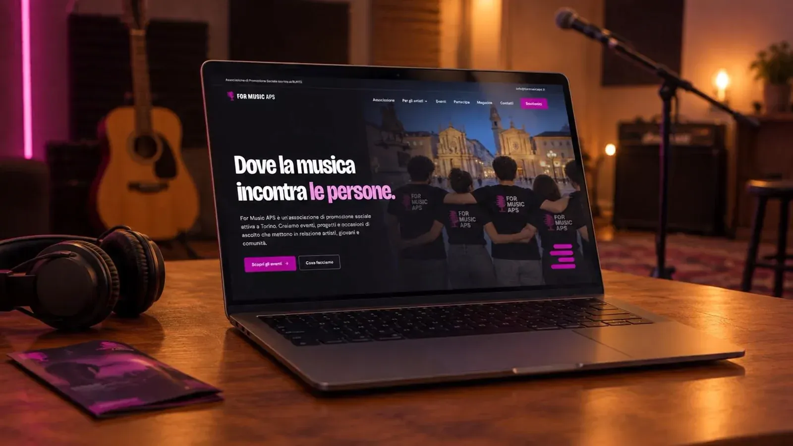 Homepage del nuovo sito di For Music APS, "Dove la musica incontra le persone.", su un portatile in una sala prove con una chitarra e un microfono sullo sfondo